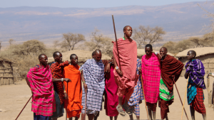 Members of a Maasai Village in colourful, patterned dress in Tanzania performing a traditional Maasai jumping ceremony captured by Annelieke Huijgens