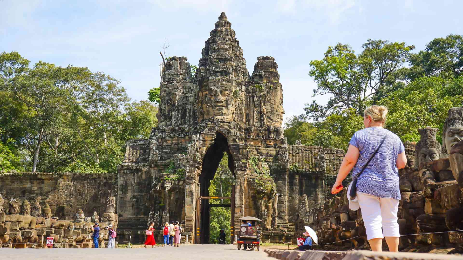 A woman walking in front of the Angkor Wat entrance on a Cambodia tour