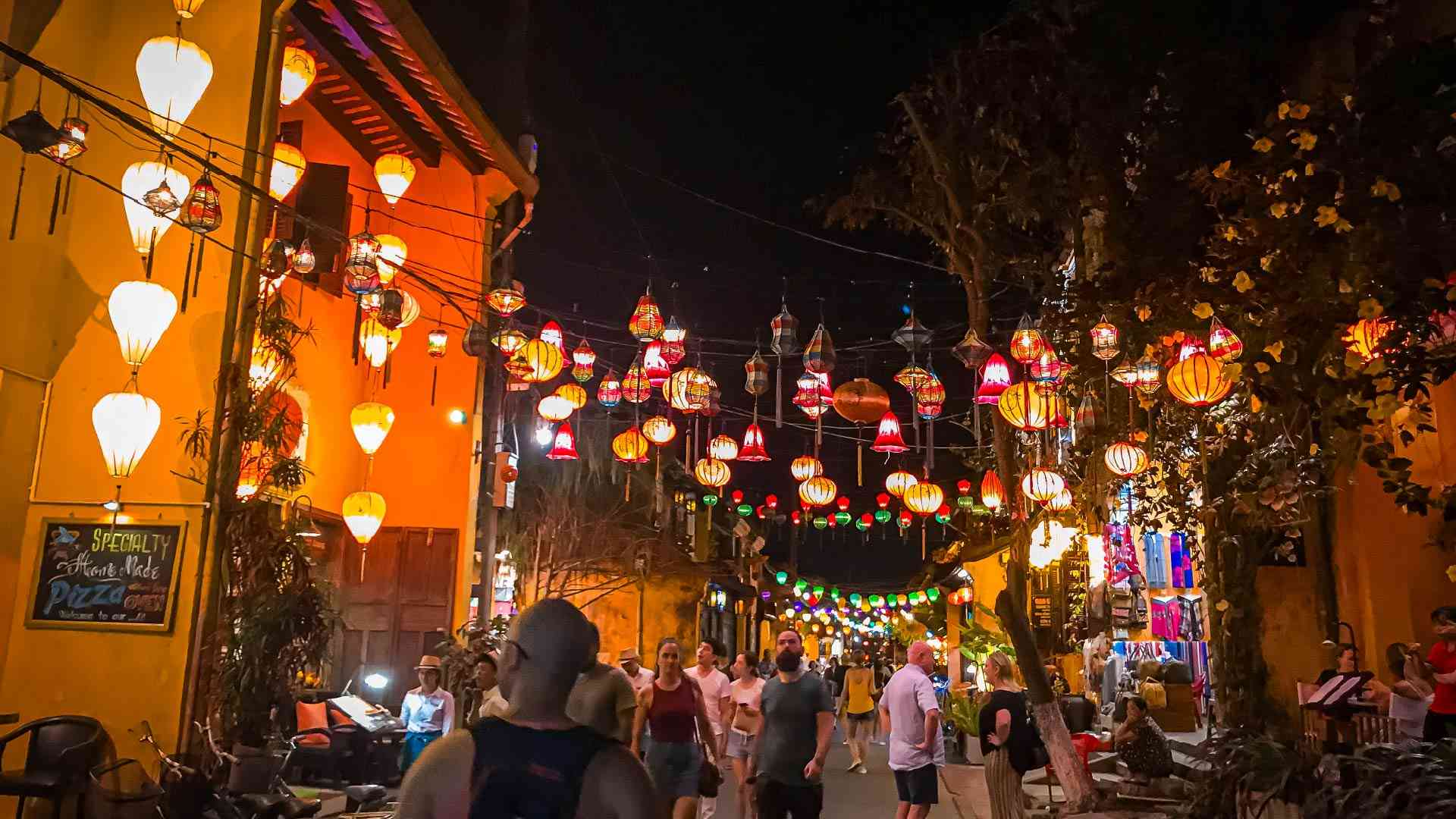 Warm coloured lanterns on a busy street in Hoi An on a Vietnam tour