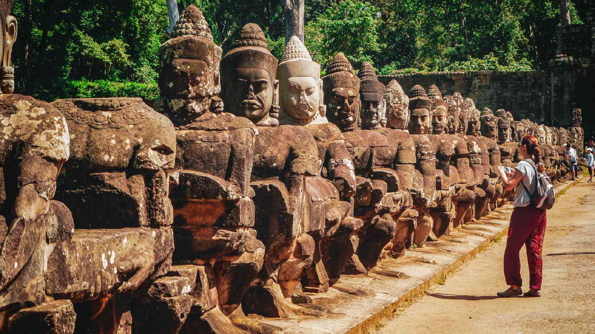 Woman looking at statues in Angkor Wat on a Cambodia tour