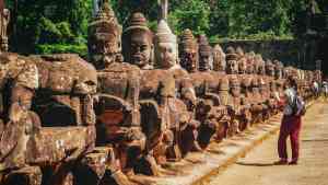 Woman looking at statues in Angkor Wat on a Cambodia tour