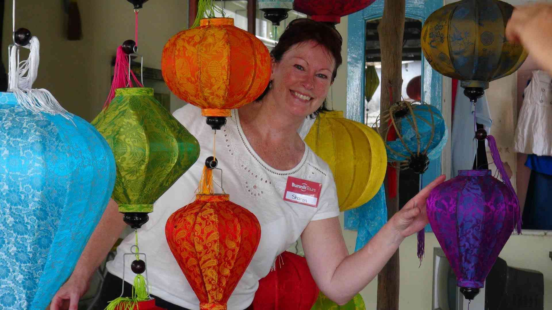 A woman posing in between lanterns in Hoi An on a Vietnam tour