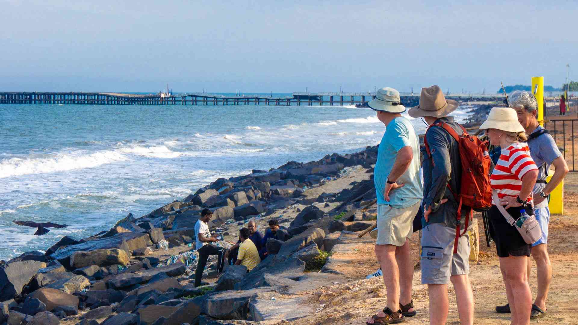 Travellers looking at the water at Promenade Beach, Pondicherry, India