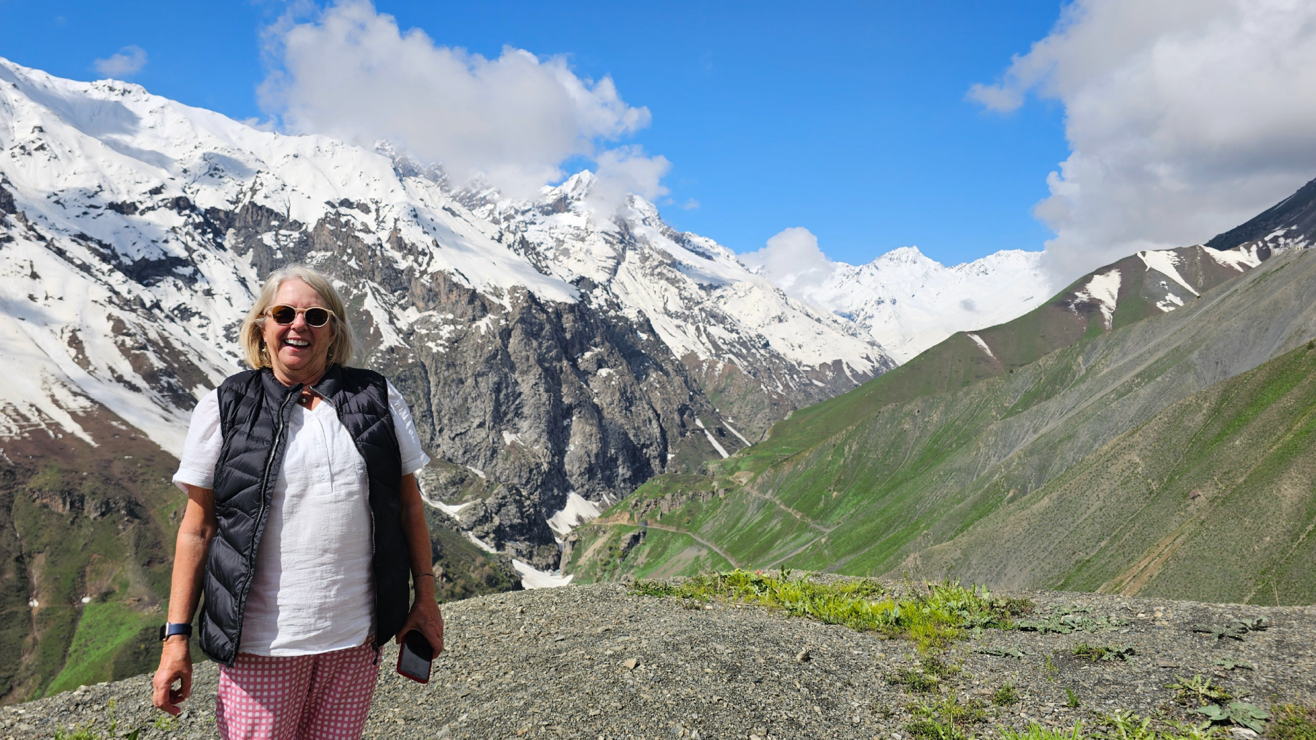 A Bunnik Tours traveller standing in front of the snowy-capped mountains of Tajikistan, captured by Dennis Bunnik