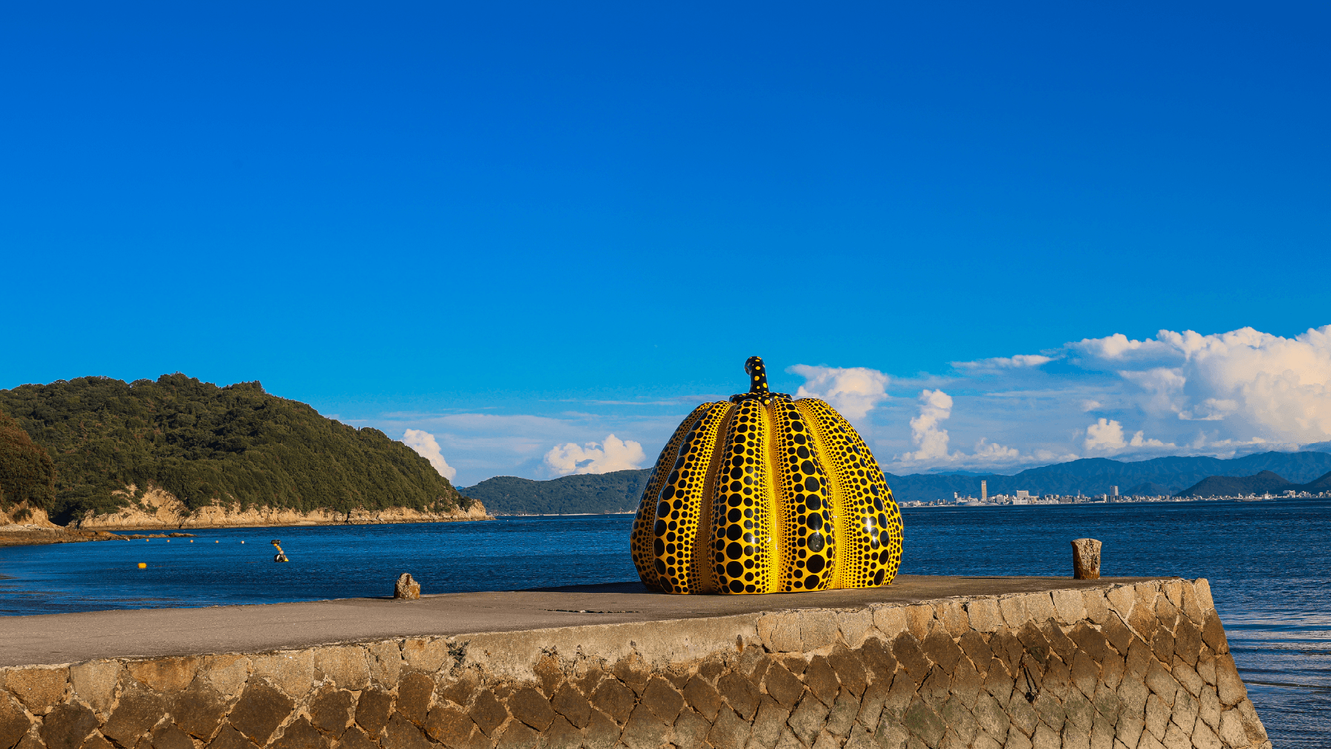 Yellow Pumpkin sculpture by artist Yayoi Kusama on the pier at Naoshima Art Island, Japan by Jeremy van Heerde