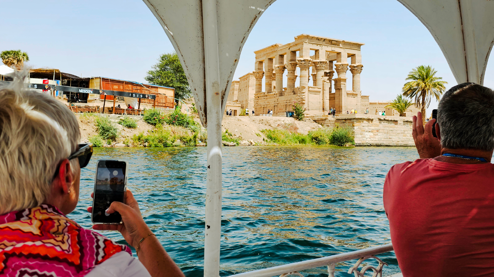 People looking at Philae Temple from the Nile River in Aswan, Egypt by Dennis Bunnik
