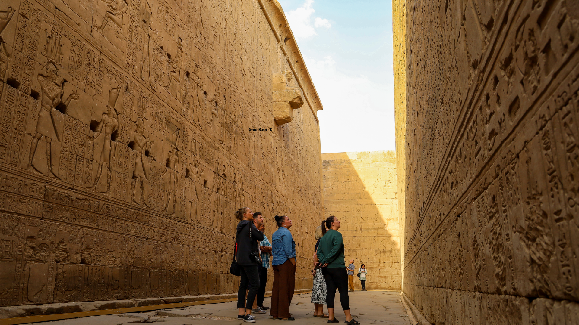 People looking at hieroglyphics at Edfu Temple, Egypt by Megan Pearce