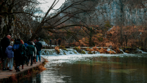 Travellers walking along the boardwalks at Plitvice Lakes National Park, Croatia by Hera Sparnon