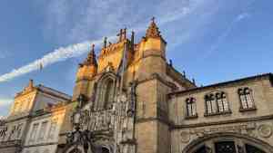 Old Building in Coimbra, Portugal, with blue, cloud-streaked sky behind